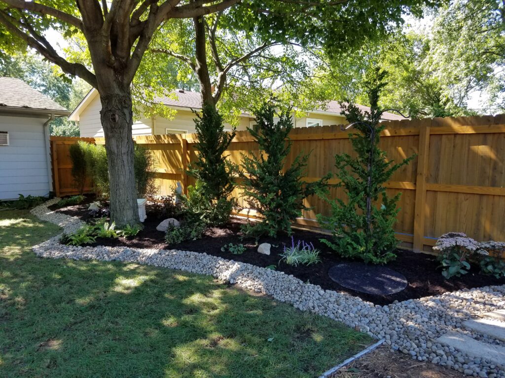 arborvitea cedar trees backyard pool mulch bed river rock border shade garden landscape design Fort Wayne Indiana